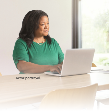 Woman typing on a laptop (actor portrayal)