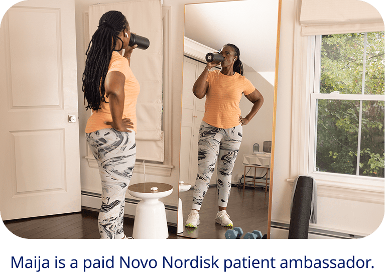 Maija, a paid Novo Nordisk spokesperson looking into a mirror drinking a water bottle