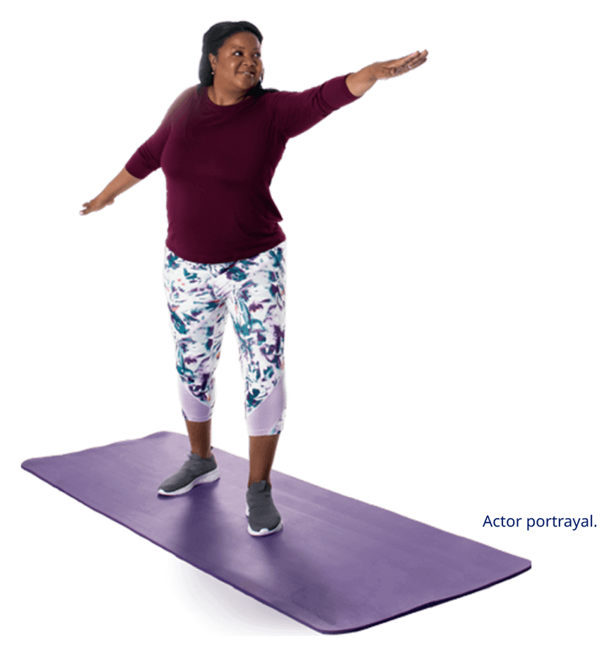 Actor portrayal of woman standing on yoga mat